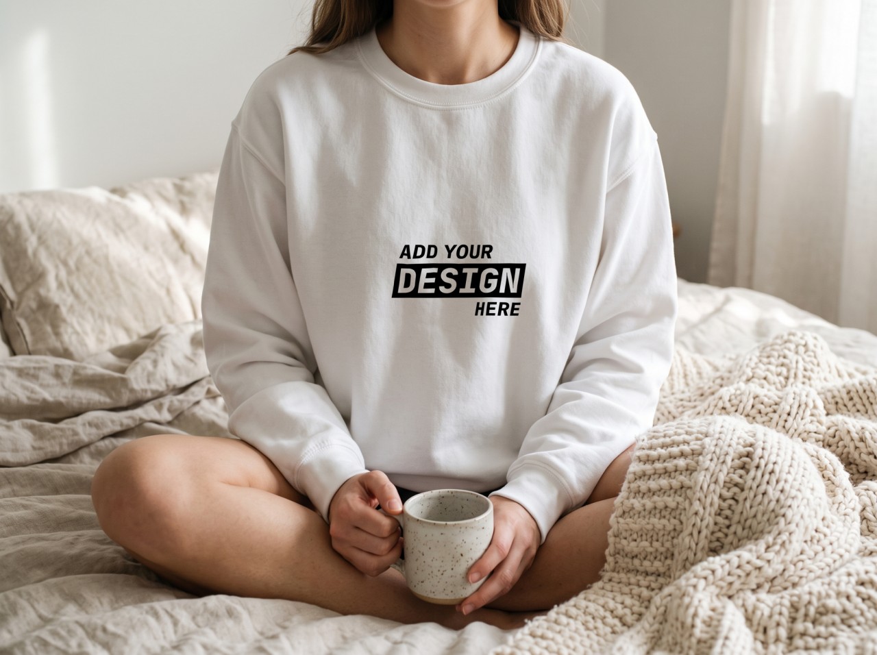 White Sweatshirt Mockup on a Woman Sitting on a Cosy Bed