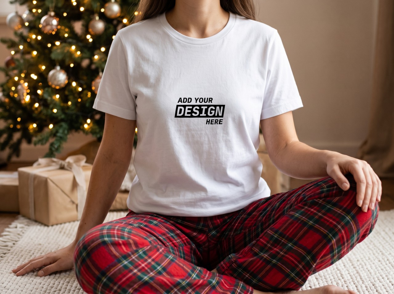 White T-Shirt Mockup on a Woman by a Christmas Tree in Plaid Pyjamas