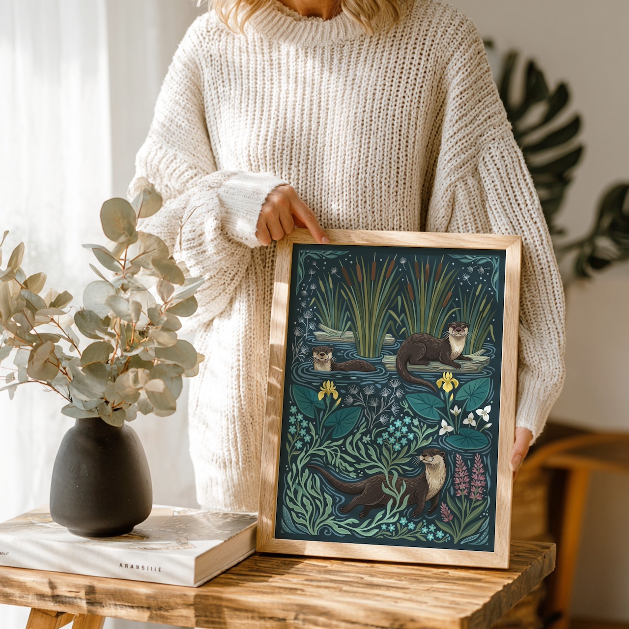 Woman holding oak poster frame with otter illustration